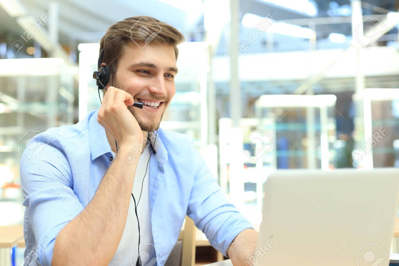 Happy young male customer support executive working in office - 122474531 Happy young male customer support executive working in office - 122474531