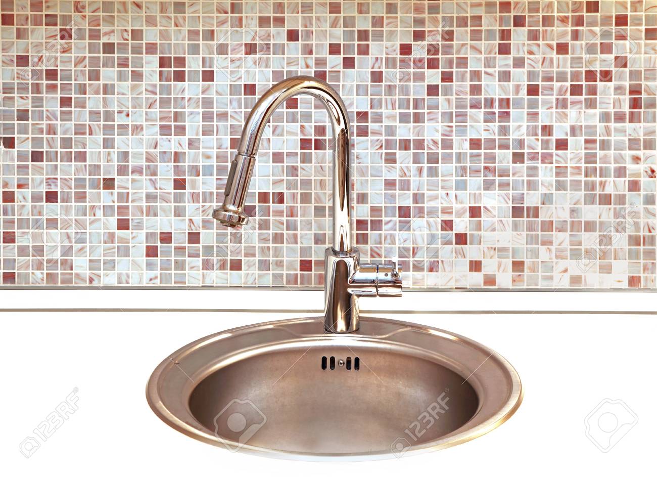 Modern kitchen faucet with mosaic tiles in background Modern kitchen faucet with mosaic tiles in background