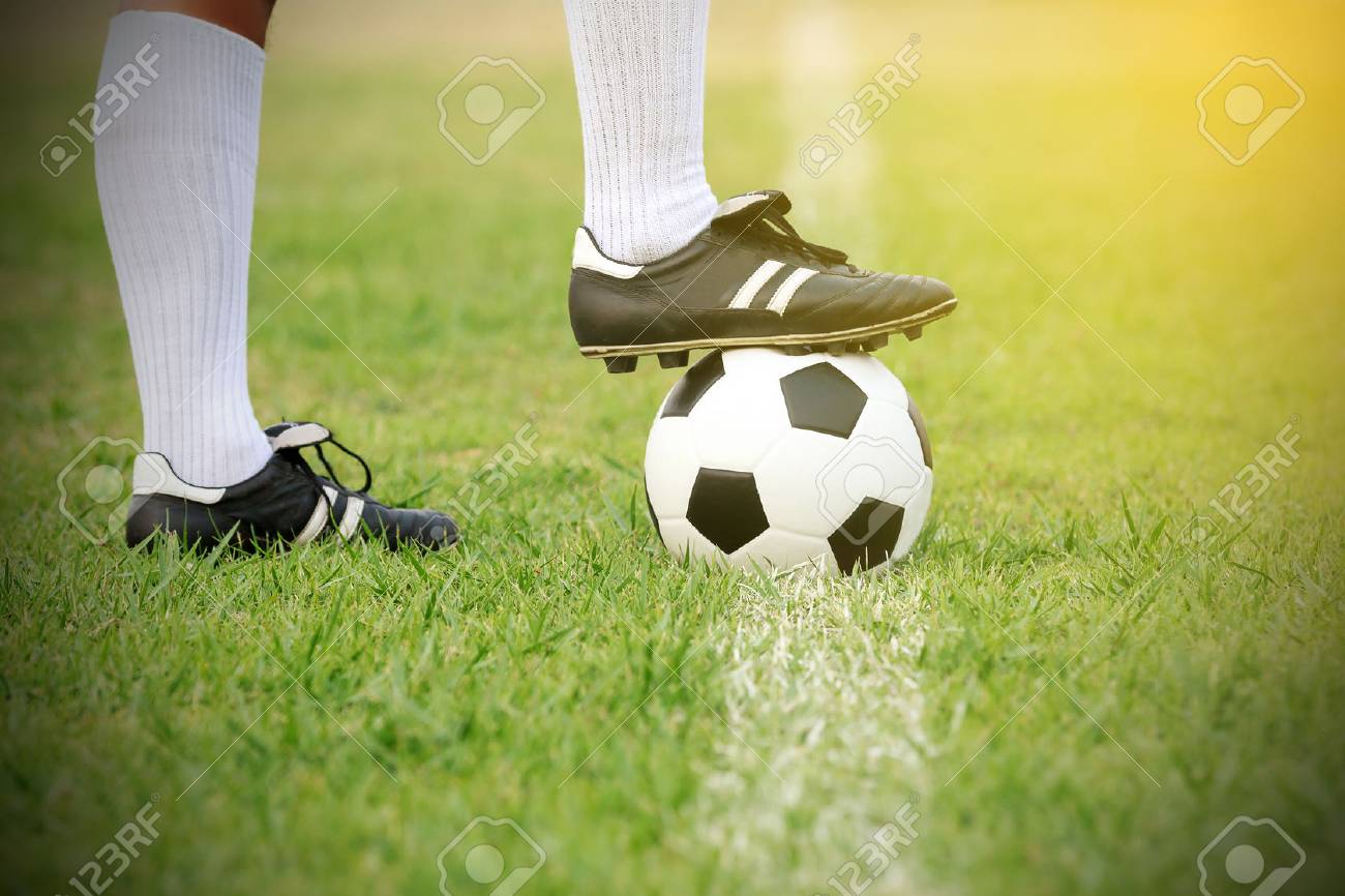 サッカー ボール キックのフィールド上のボールを持って立っているサッカーまたはフットボールのプレーヤー の写真素材 画像素材 Image