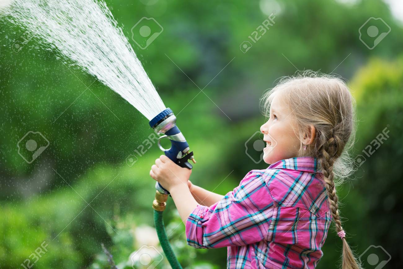 ホースで庭の花の水やりの女の子 の写真素材 画像素材 Image