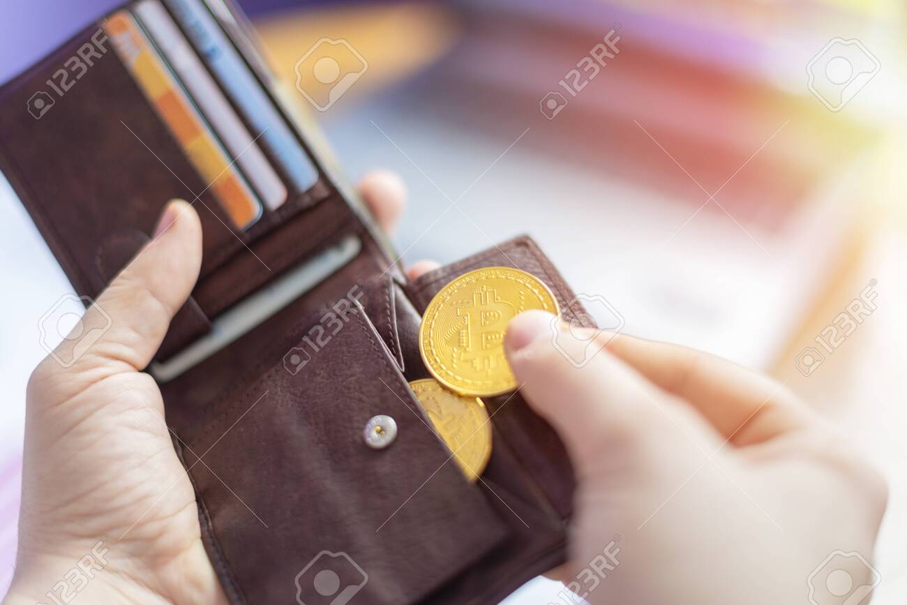 가상 황금 비트코인을 지갑에 넣는 손 로열티 무료 사진, 그림, 이미지 그리고 스톡포토그래피. Image 122225583