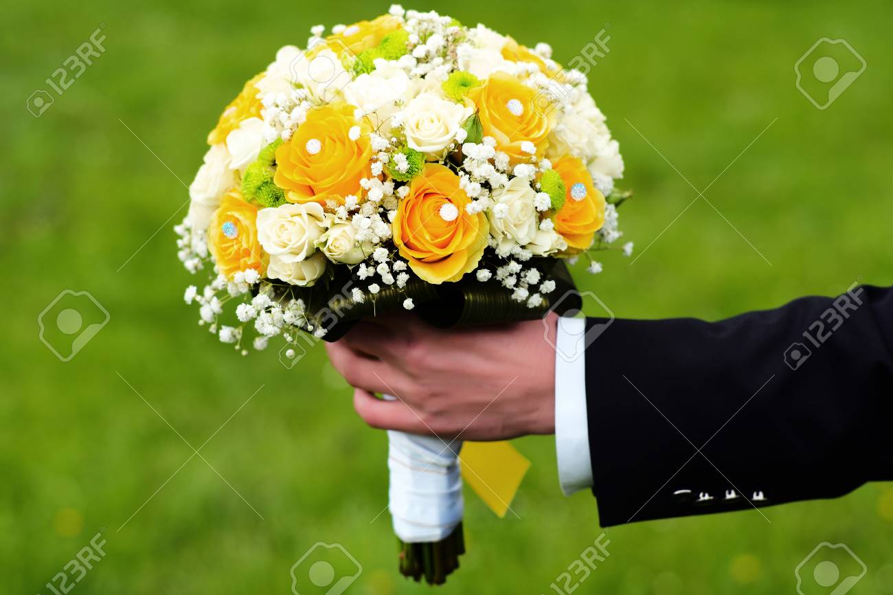 白と黄色のバラの花束を明るい結婚式を保持するには、屋外グリーン自然