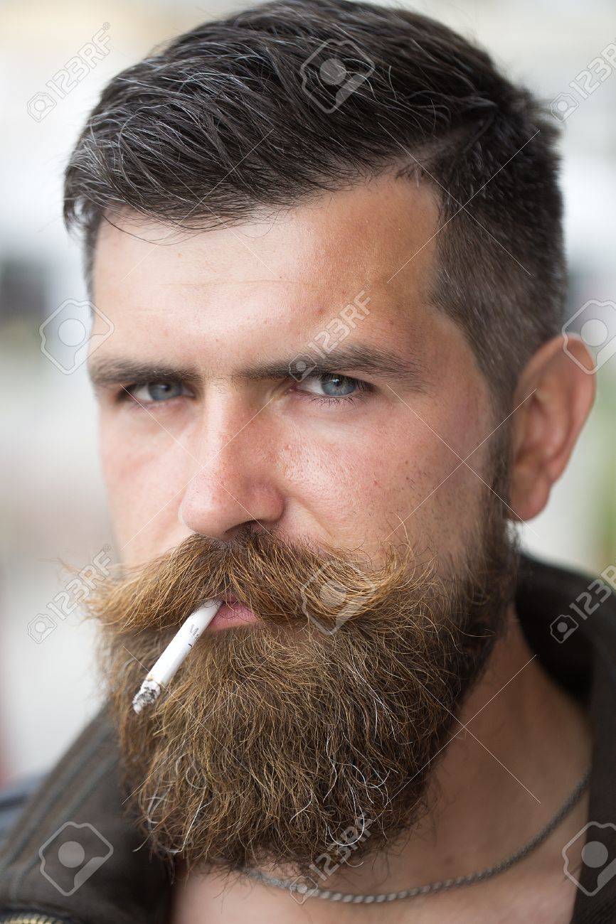 Portrait Of Handsome Unshaven Guy Smoker With Beard And Handlebar