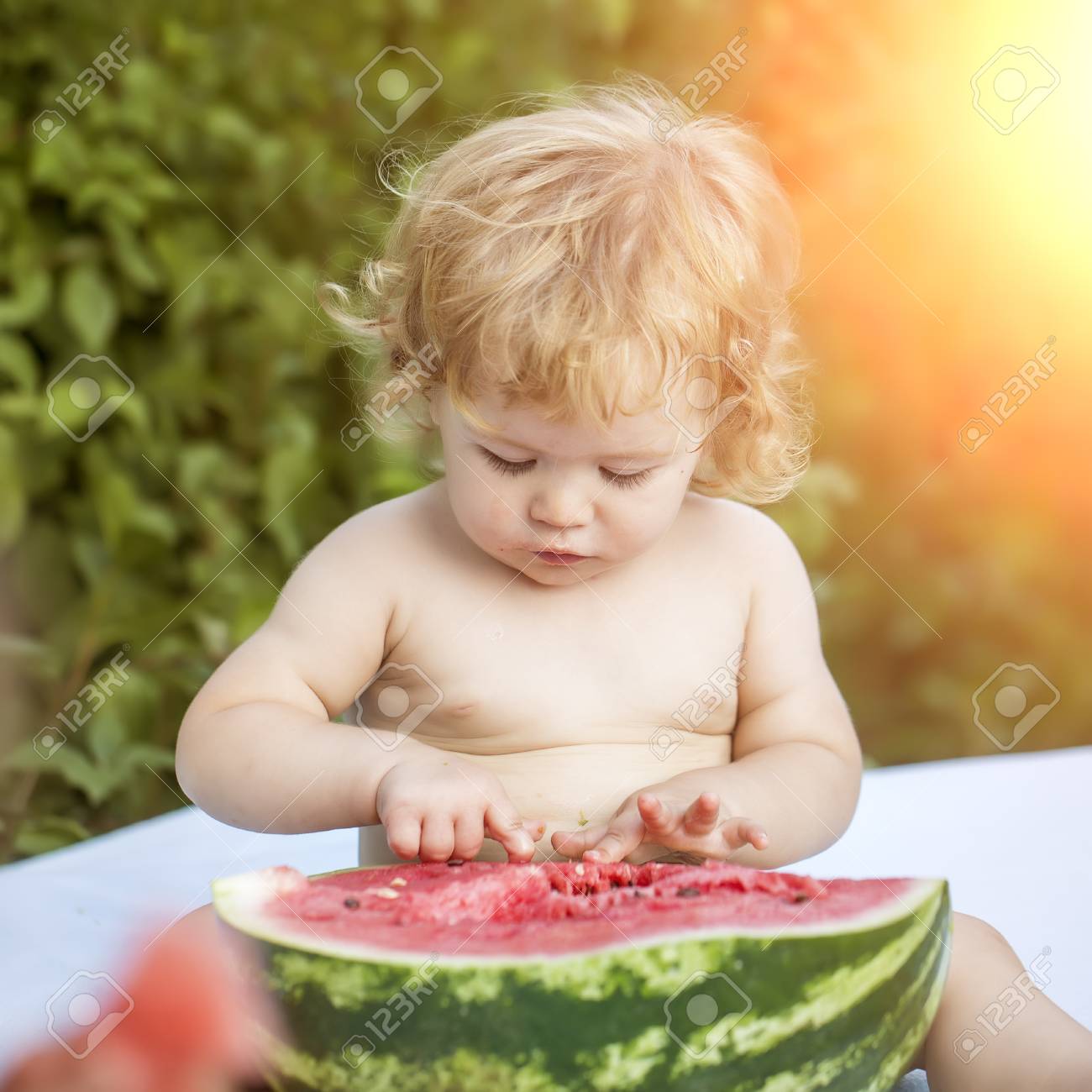 One Small Cute Boy With Blonde Curly Hair And Round Cheeks Sitting Stock Photo Picture And Royalty Free Image Image