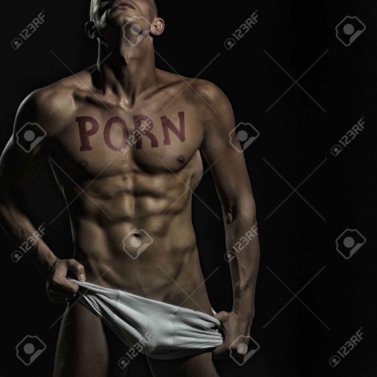一個英俊脫了衣服肌肉男子在白色內衣美麗性感的身體與紅色唇膏寫有trown站在背頭工作室在黑色背景的色情文字，圖片廣場