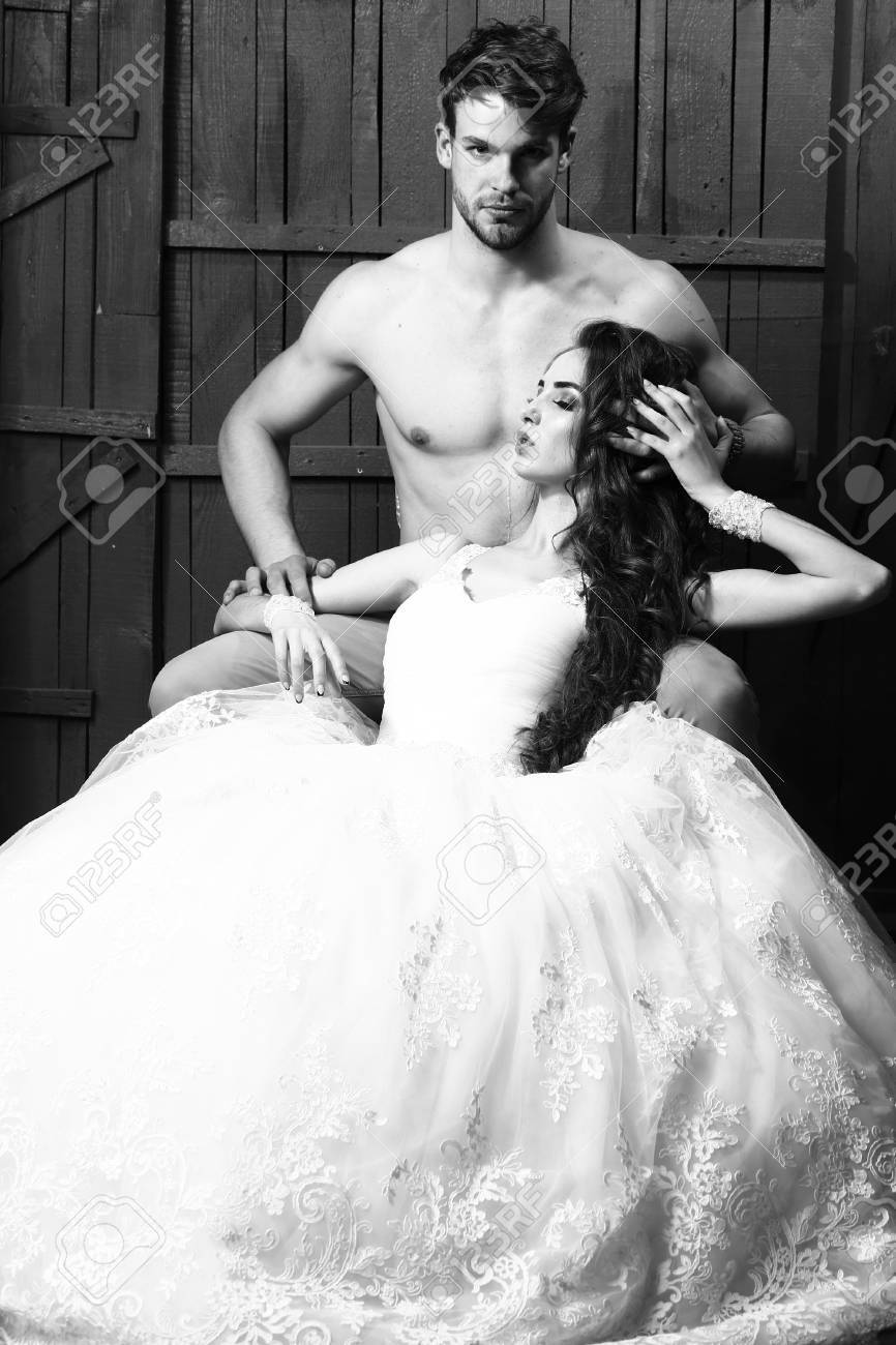 Bride In Wedding Dress And Handsome Young Man With Naked Torso And Muscular Body Posing In Studio, Black And White Stock Photo, Picture And Royalty Free Image