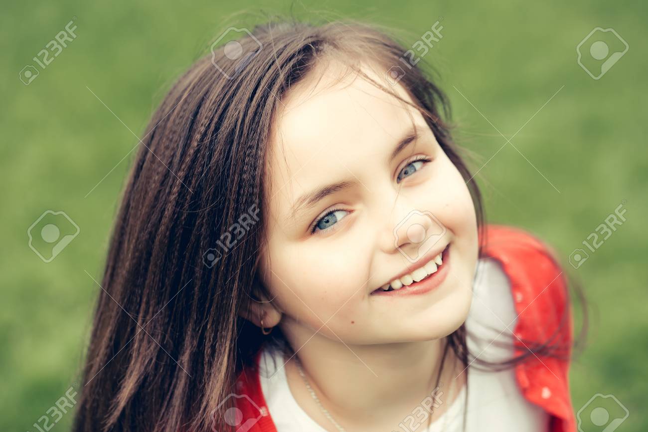 La Cara Sonriente Del Nino Pequeno Y Lindo Feliz Nina De Ojos Azules Y De Cerca Al Aire Libre Morena De Pelo En El Fondo Verde Enmascarado Fotos Retratos Imagenes Y Fotografia