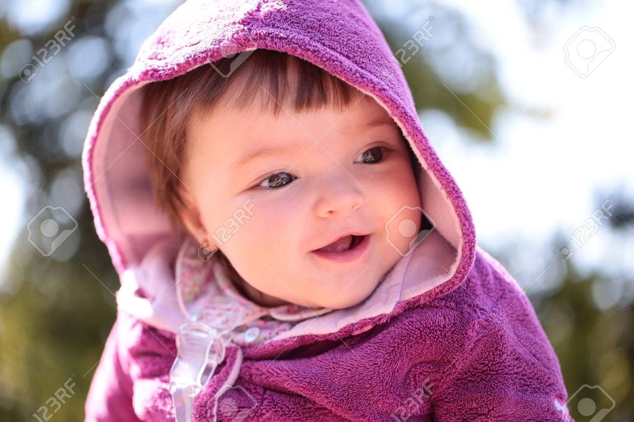 small cute baby girl with pretty smiling face and funny eyes stock