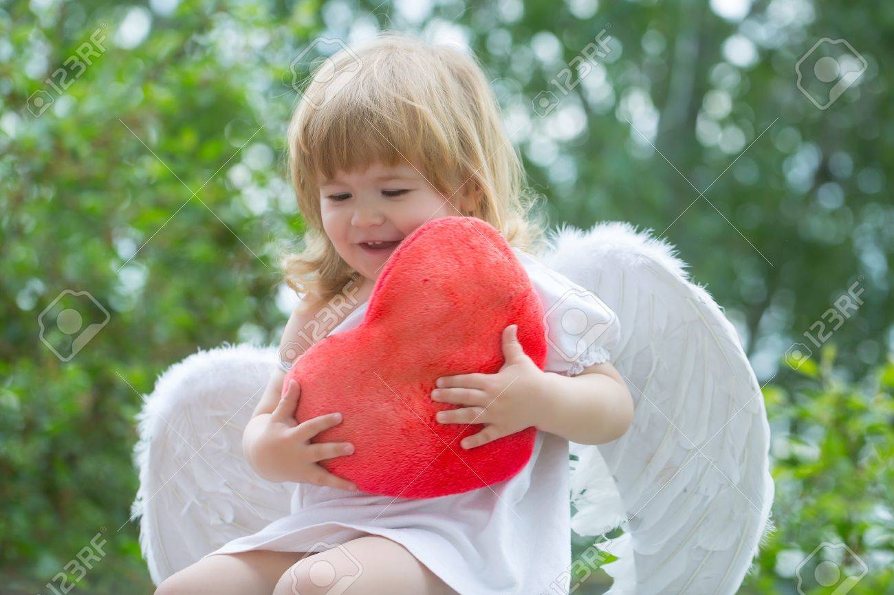 small cute baby boy with blonde long hair in white feathered stock