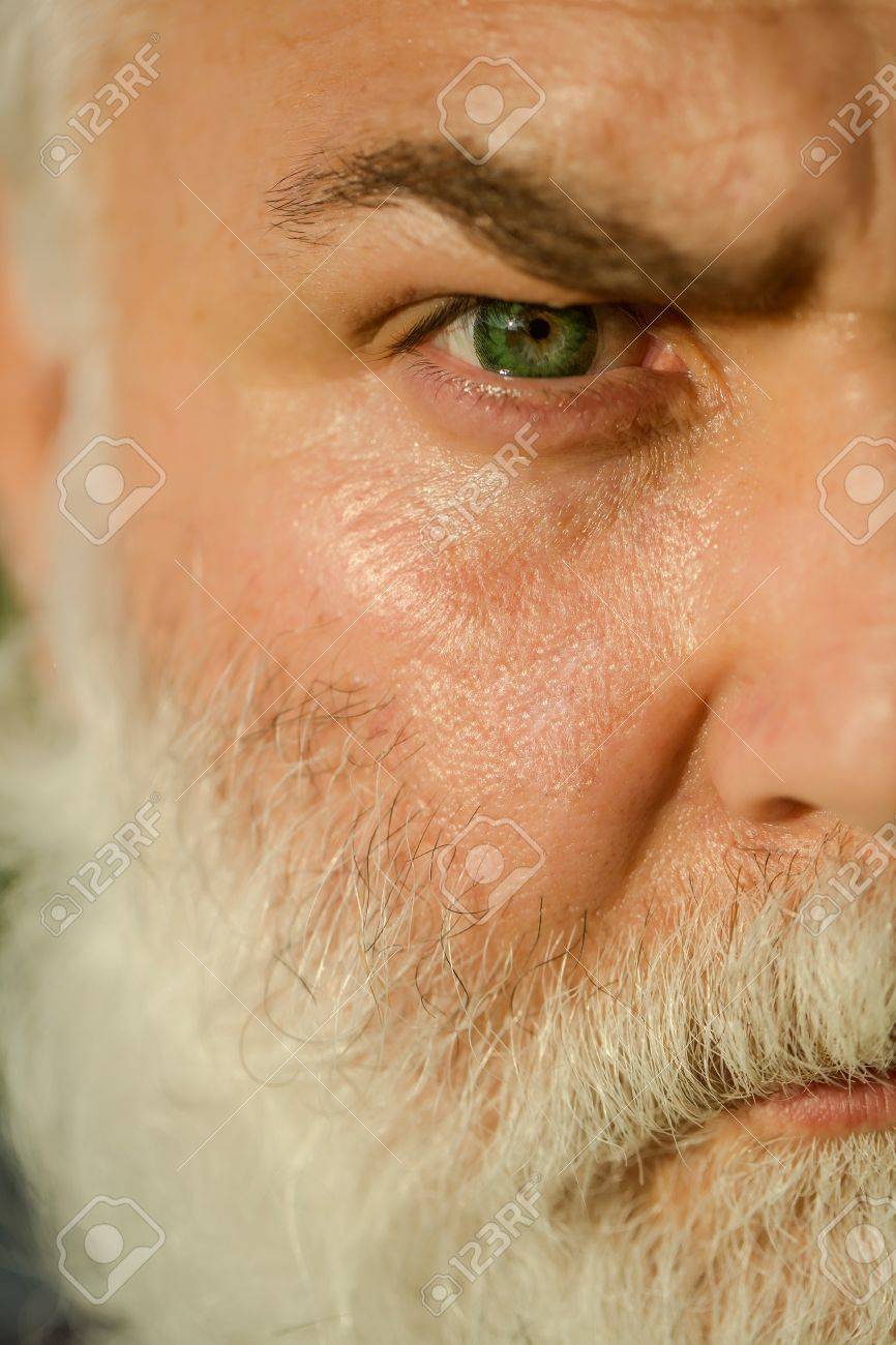 義母の明るいレンズと毛深い眉毛男性目昔のひげを生やした肌をしわとクローズ アップの深刻な顔に長いひげを持つ男 の写真素材 画像素材 Image