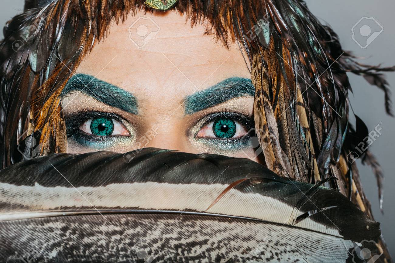 エメラルド グリーン色のアイブロウとアイシャドウ化粧大きな黒い羽を近く頭羽のクローズ アップで飾られた装飾的なコンタクト レンズが付いているハンサムな目で男性の顔 の写真素材 画像素材 Image エメラルド グリーン色のアイブロウとアイシャドウ化粧大きな黒い羽を近く頭羽のクローズ アップで飾られた装飾的なコンタクト レンズが付いているハンサムな目で男性の顔 の写真素材 画像素材 Image
