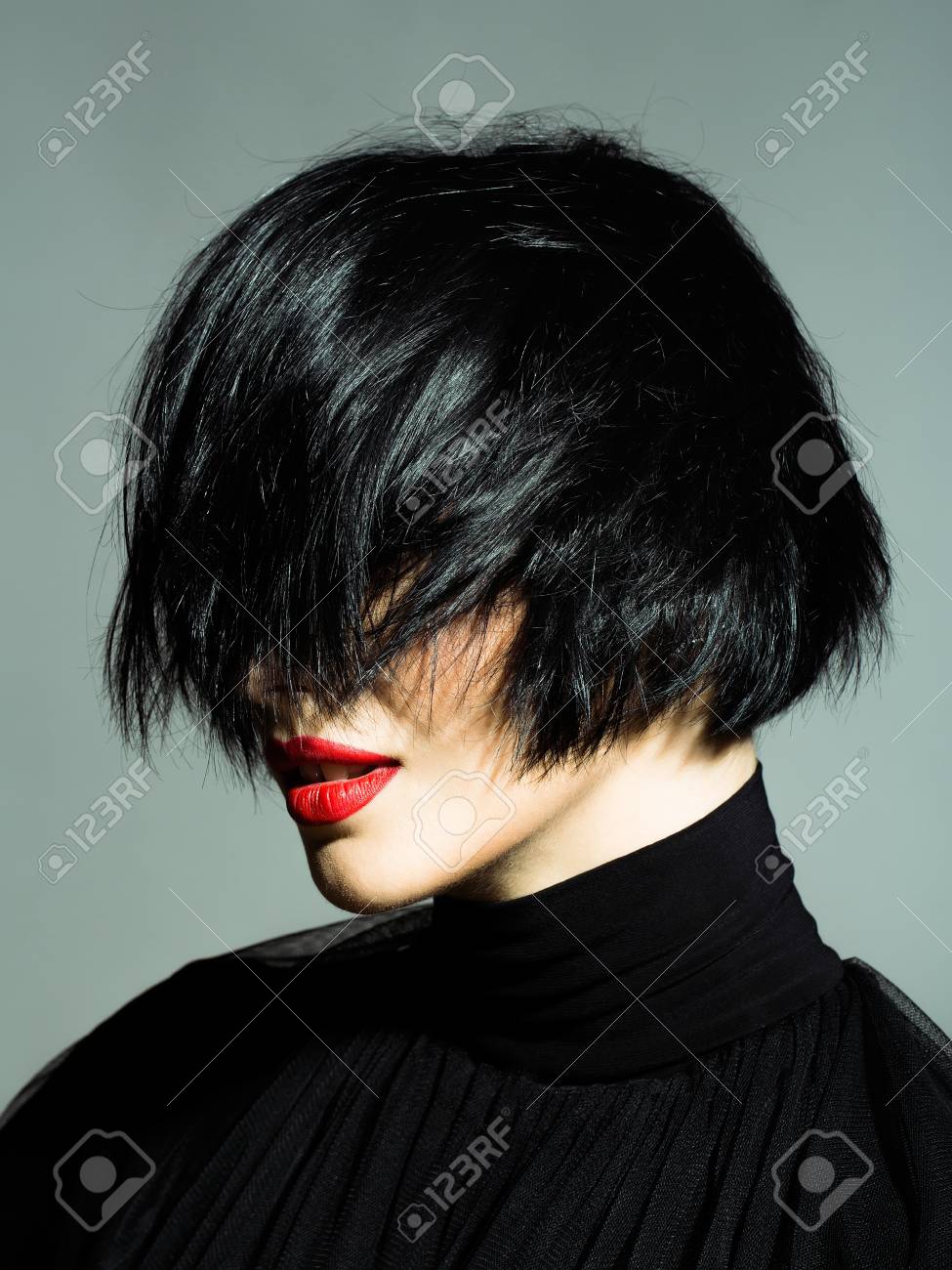 Mujer Atractiva Joven O Nina Con El Pelo Corto Morena Elegante Y Los Labios Rojos En Cara Bonita En El Pano Negro Sobre Fondo Gris De Cerca Fotos Retratos Imagenes Y Fotografia