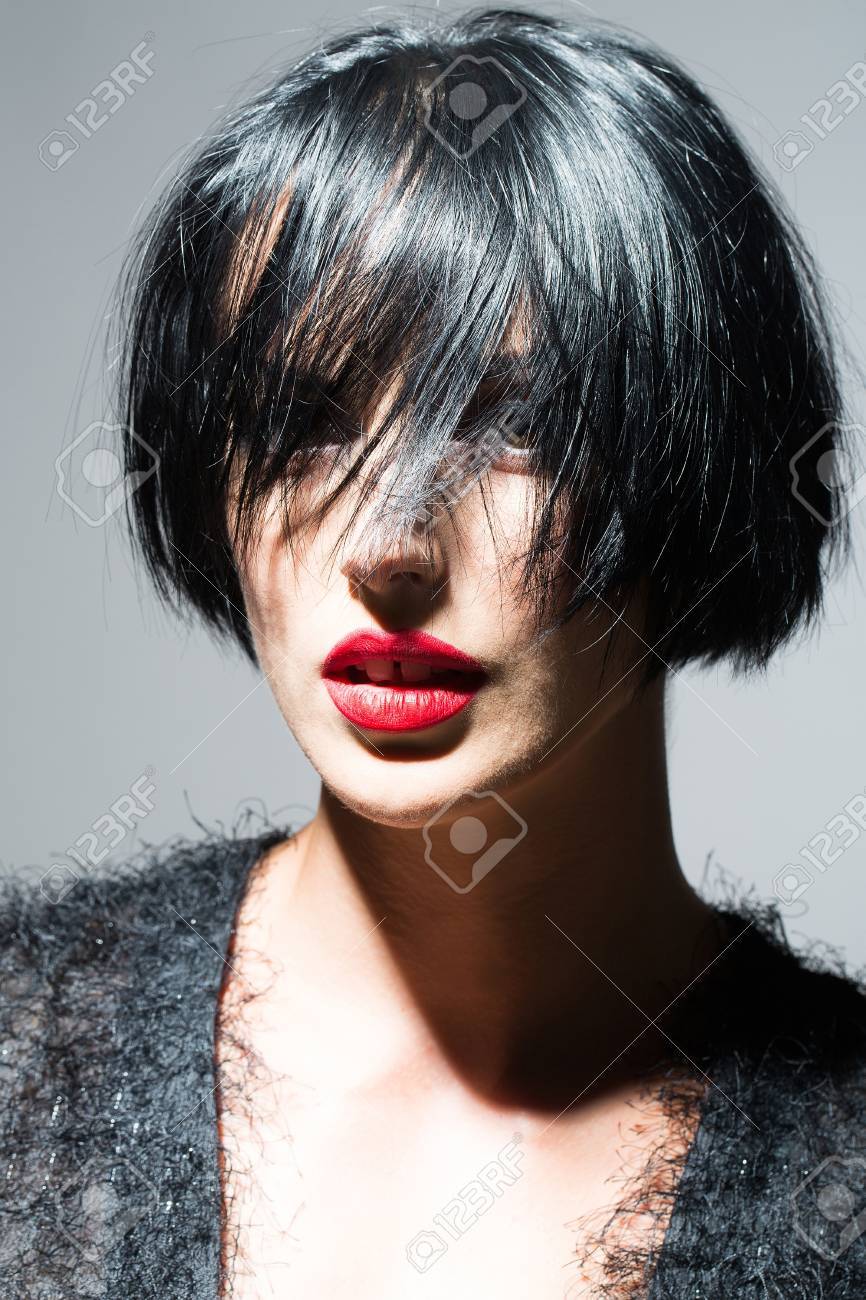 Mujer Joven O Nina Con El Pelo Corto Morena Elegante Y Los Labios Rojos En Cara Bonita En El Pano Negro Sobre Fondo Gris De Cerca Fotos Retratos Imagenes Y Fotografia De