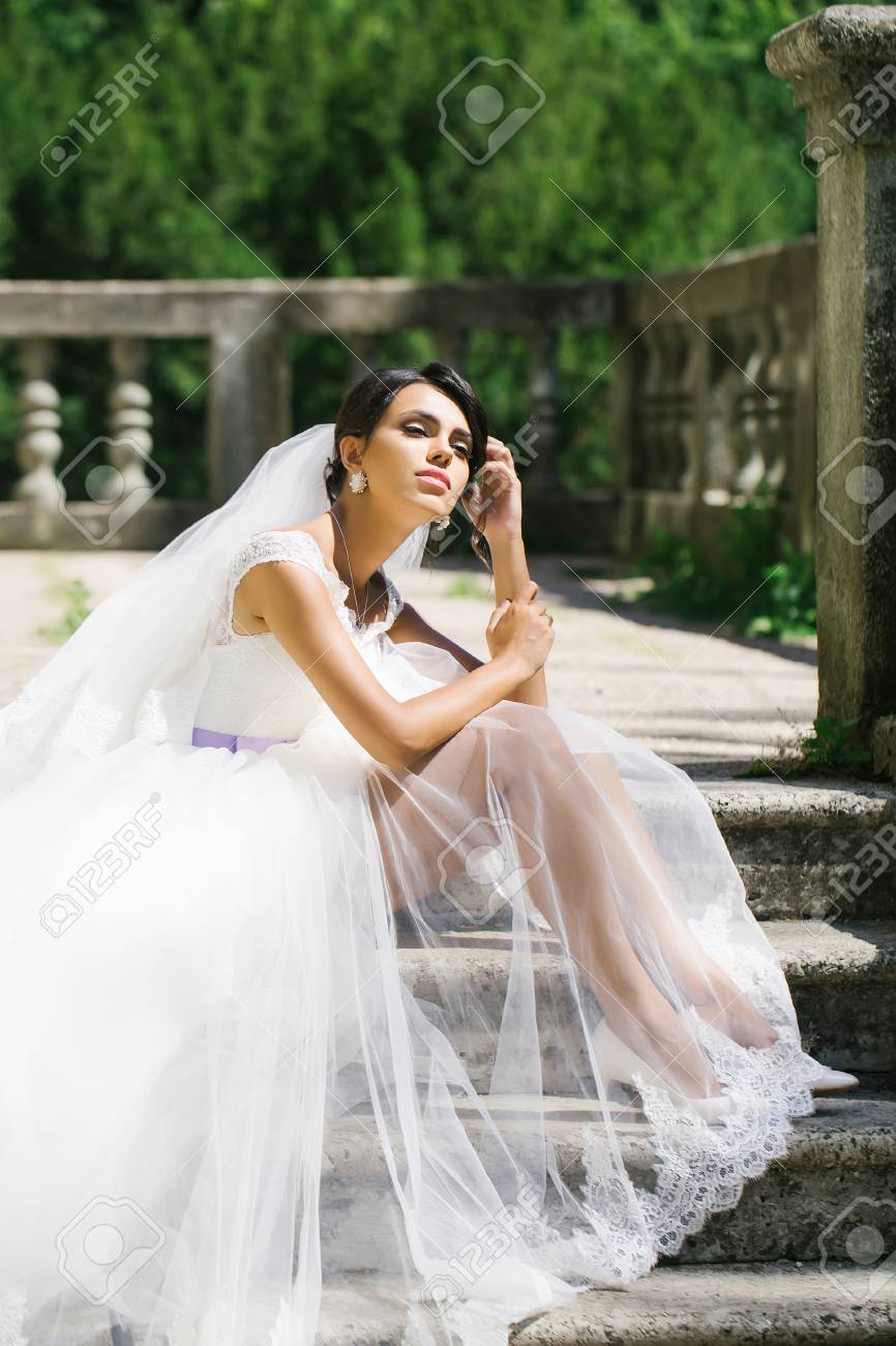 Gorgeous bride woman in elegant transparent lace wedding dress..