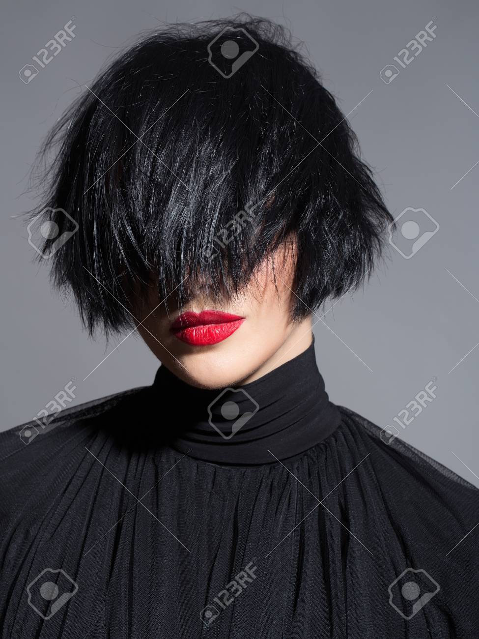 Mujer Joven O Nina Con El Pelo Corto Morena Elegante Y Los Labios Rojos En Cara Bonita En El Pano Negro Sobre Fondo Gris De Cerca Fotos Retratos Imagenes Y Fotografia De