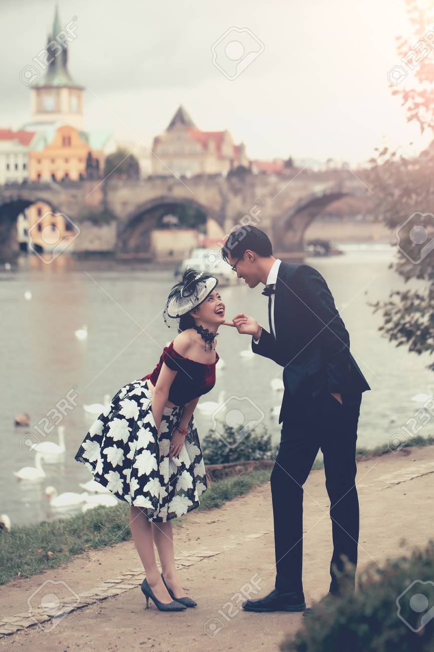 Lustige Chinesische Gluckliche Paar Von Hubschen Madchen Und Gut Aussehend Mann Im Retro Oder Vintage Kleid Und Anzug Halten Fauste Ok Ja Sieger Geste Im Freien Auf Der Flussseite Lizenzfreie Fotos Bilder Und Stock