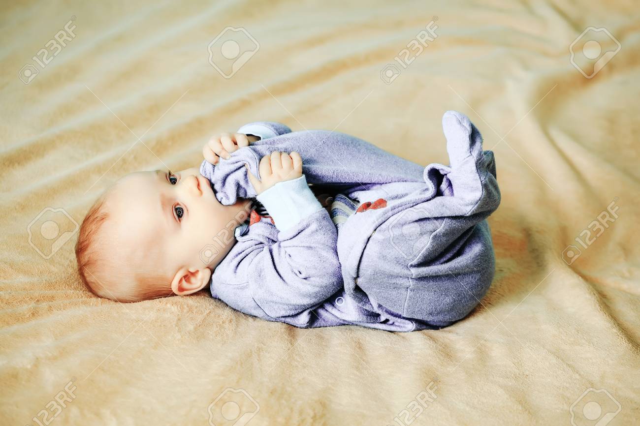 Petit Bebe Mignon En Adorable Bombardier Bleu Mord Son Pied Sur Le Lit Banque D Images Et Photos Libres De Droits Image Petit Bebe Mignon En Adorable Bombardier Bleu Mord Son Pied Sur Le Lit Banque D Images Et Photos Libres De Droits Image