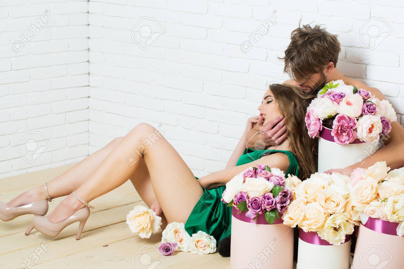 セクシーなカップル若い美しい愛の花の箱にかなり女の子と Sexi 男のかわいい恋人白いレンガの壁の床コピー領域を抱っこ の写真素材 画像素材 Image