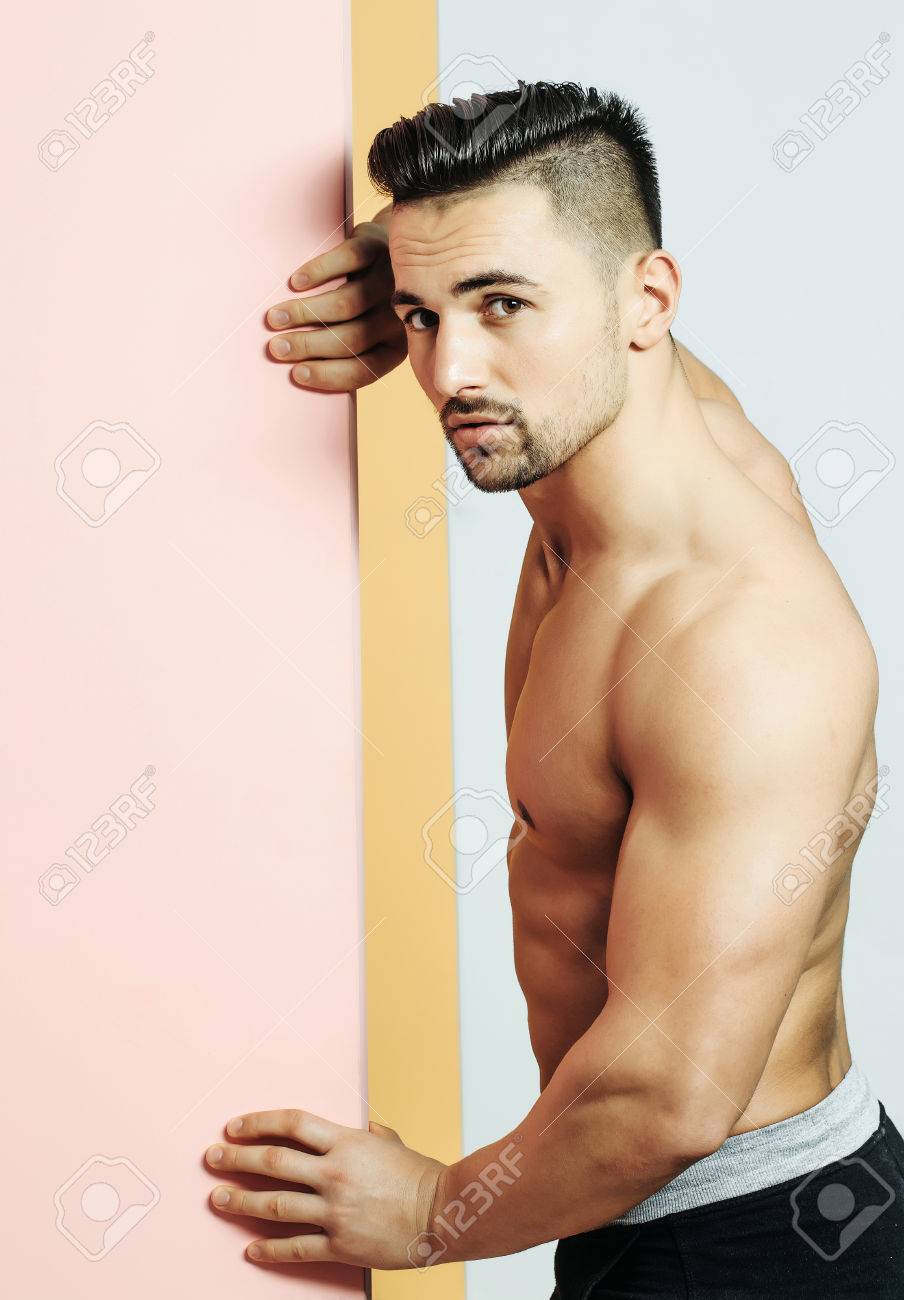 ハンサムな男または筋肉マッチョ ボディービルダー 毛 ヘアスタイル セクシーな筋肉トルソ ボディ 上腕三頭筋 上腕二頭筋ポージング ピンクのドアに の写真素材 画像素材 Image