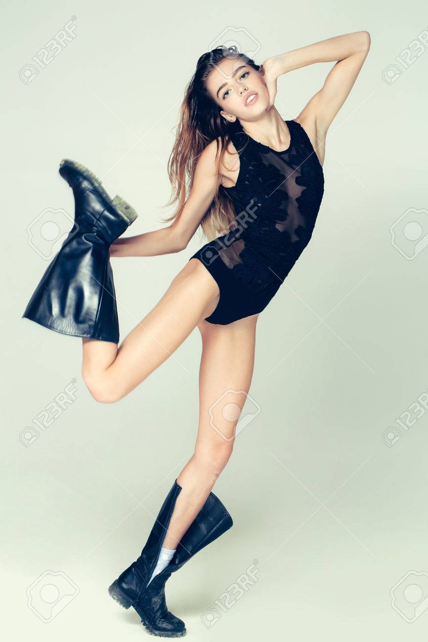 Stock Photo Young Pretty Woman Or Cute Sexy Girl With Long Wet Hair And Flexible Body In Fashionable Black Lace Bodysuit And Dirty Boots Poses On White Stock Photo Young Pretty Woman Or Cute Sexy Girl With Long Wet Hair And Flexible Body In Fashionable Black Lace Bodysuit And Dirty Boots Poses On White