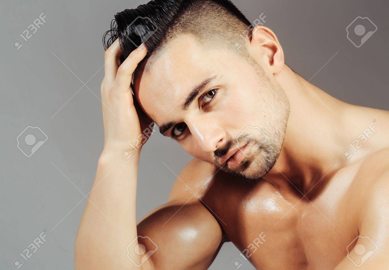 ハンサムな男または筋肉マッチョ ボディービルダー 毛 ヘアスタイル 脂性肌 セクシー 筋肉トルソ ボディ 上腕三頭筋 上腕二頭筋ポージング灰色の背景上で の写真素材 画像素材 Image