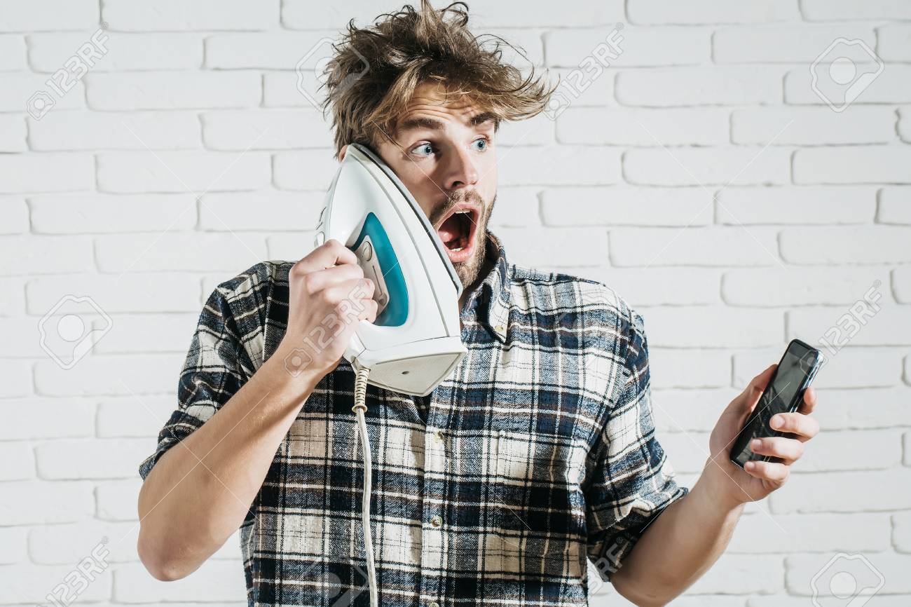 Handsome Surprised Man With Messy Hair With White Iron At His