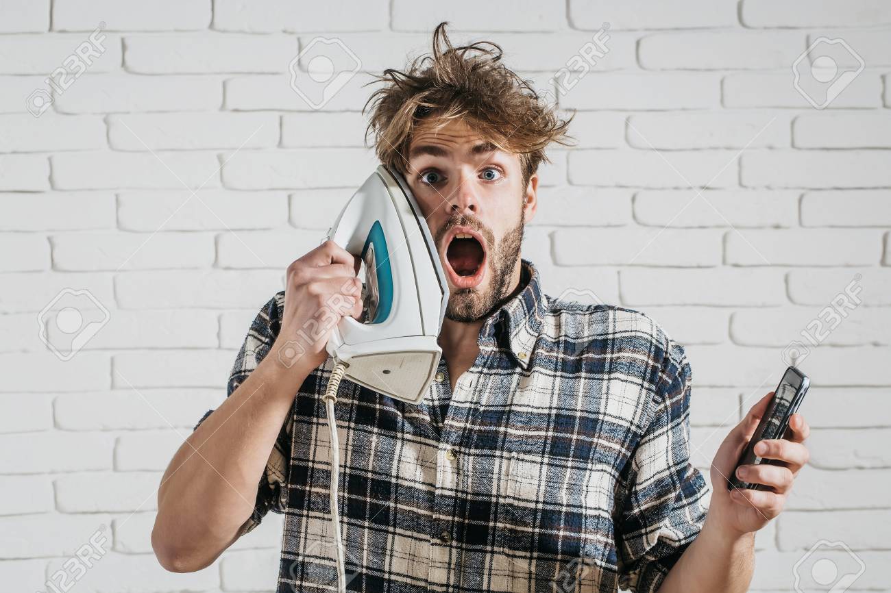 Handsome Surprised Man With Messy Hair With White Iron At His