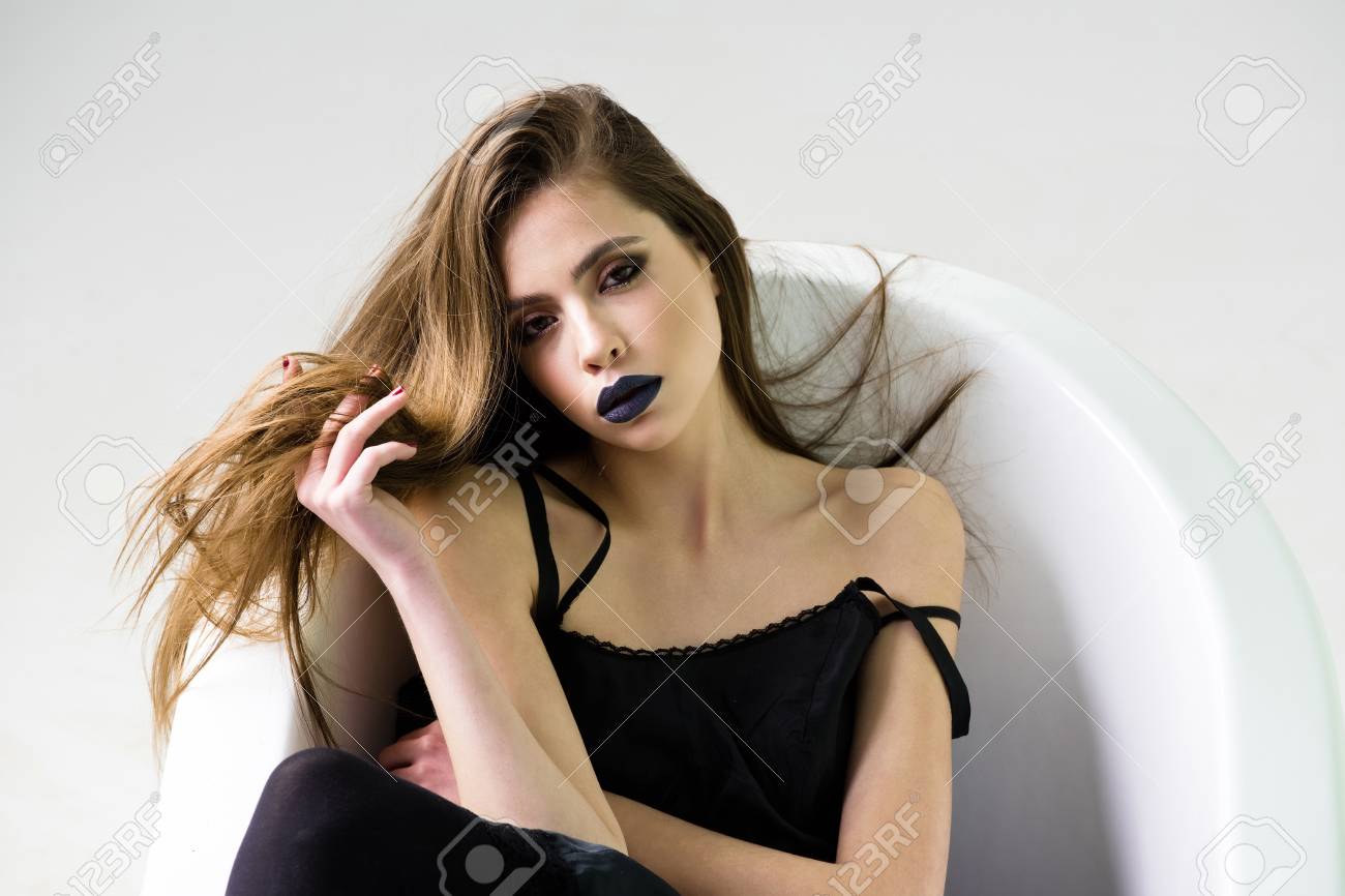Femme Ou Jolie Jeune Fille Brune Caucasienne En Robe Avec Les Cheveux Longs Et Le Rouge à Lèvres Noir Sur Les Lèvres Se Trouvant Dans La Baignoire