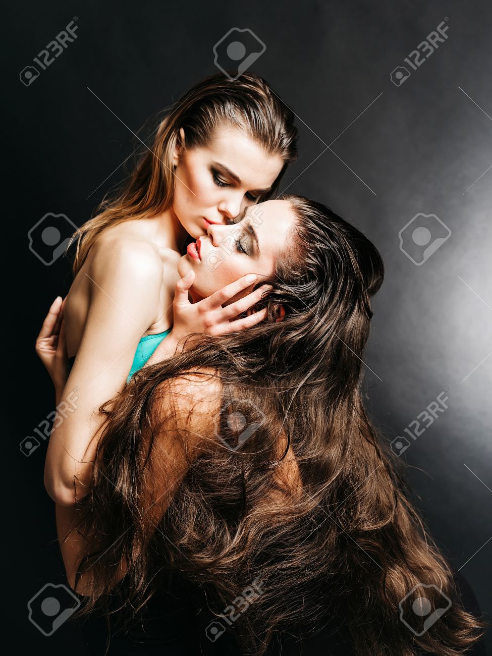 女性 2 つのセクシーな女の子やきれいな女性 美しい長い髪とスタイリッシュなメイク ハグと灰色の背景にキスのファッショナブルなモデルの同性愛者カップルは セックスの性的魅力 の写真素材 画像素材 Image