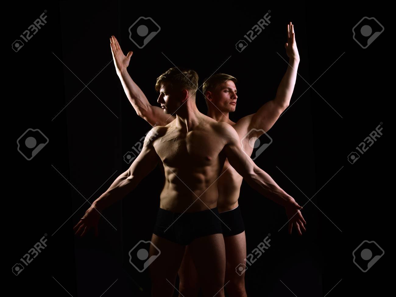 Hombres Gemelos Musculares Con Torso Desnudo Y Seis Paquetes En Ropa Interior Con Cuerpo Atlético Sobre Fondo Negro, Alter Ego, Fotos, Retratos, Imágenes Y Fotografía De Archivo Libres De Derecho. Image