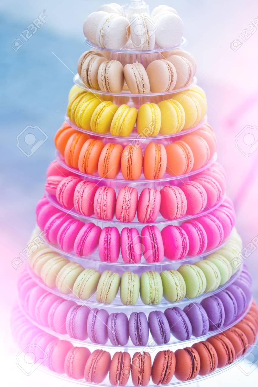 Colorful french macarons, multilevel cake pyramid, on plastic, dessert stand or plate on blurred background. Food, dieting. Birthday, anniversary, wedding celebration - 80037070 Colorful french macarons, multilevel cake pyramid, on plastic, dessert stand or plate on blurred background. Food, dieting. Birthday, anniversary, wedding celebration - 80037070