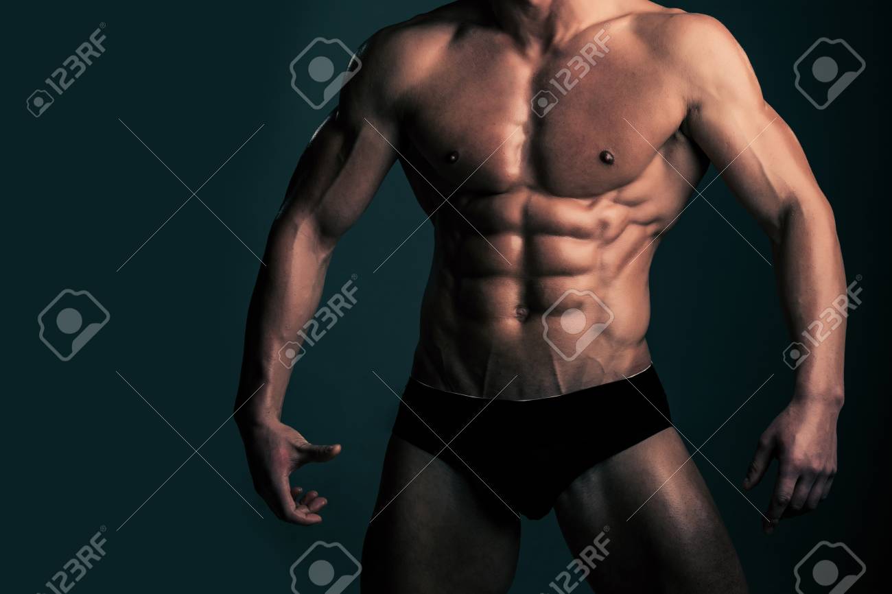 筋肉 マッチョな体と下着のパンツでポーズでボディービルダー選手の強い胴体でセクシーな男裸の胸と腹のグレーの背景 スポーツ トレーニングの の写真素材 画像素材 Image