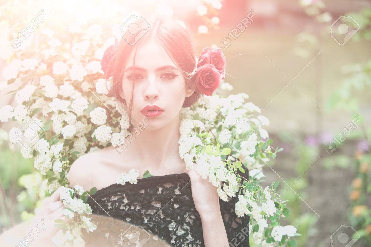 Fille à Maquillage à La Mode Et Lèvres Rouges A Une Fleur De Rose En Cheveux Hispanique Ou Espagnol En Robe Noire Au Printemps Blanc Ou Fleur Dété