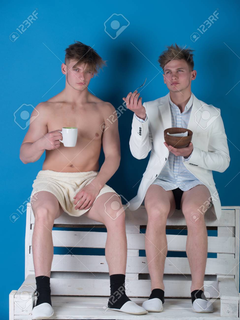 青の背景に木製のベンチに座っている男性 シャツ ジャケットとパンツを身に着けているビジネスマン タオルに包まれた筋肉質の胴体とマッチョ 飲むと 健康的な ダイエットします ファッションやフィットネスの概念 の写真素材 画像素材 Image