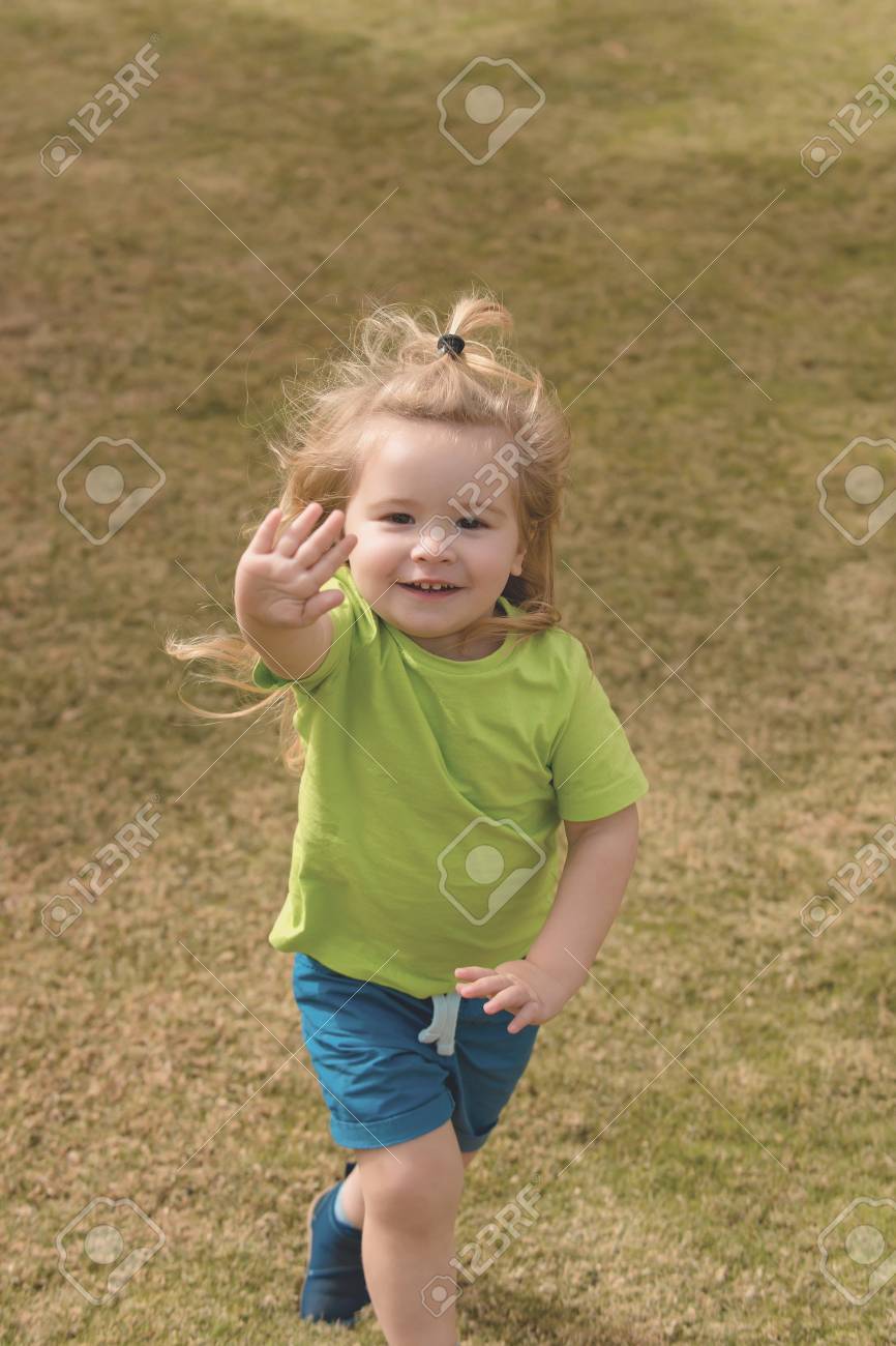 Kleiner Junge im grünen Hemd läuft und kurze Hosen, Kind i Kleiner Junge im grünen Hemd läuft und kurze Hosen, Kind i