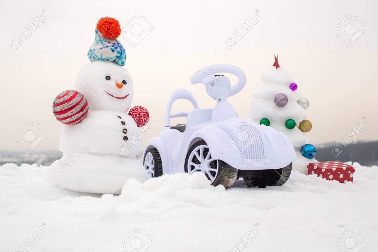 冬の日のスマイルと雪の彫刻 クリスマスと新年 クリスマス ツリーと白い空にプレゼント ボックス 休日のお祝いのコンセプトです 雪の背景に雪だるまとおもちゃの車 の写真素材 画像素材 Image