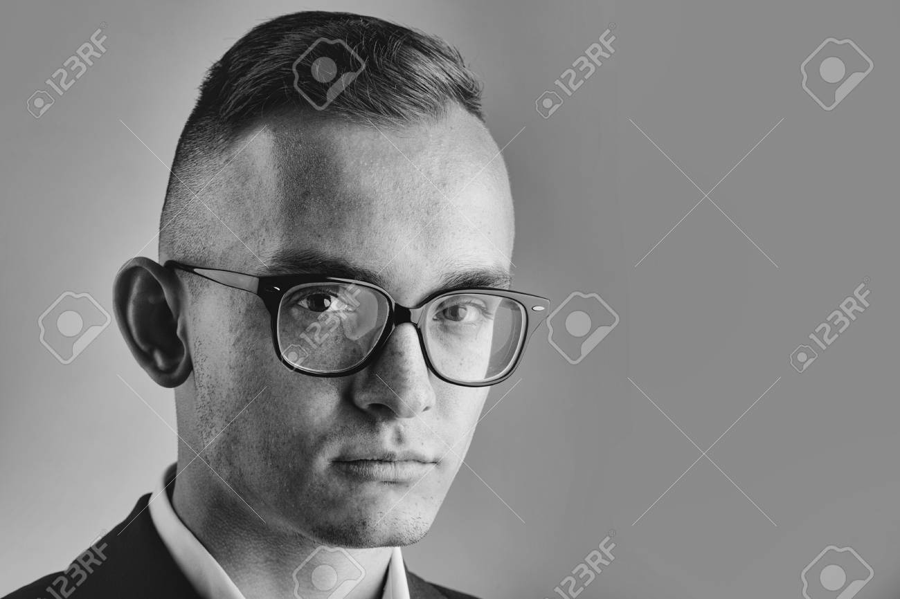 オタクのメガネを持つ若いファッションのビジネスマン ジャケットのスタイリッシュな髪型は グレーの背景にポーズ コピースペース の写真素材 画像素材 Image 6192