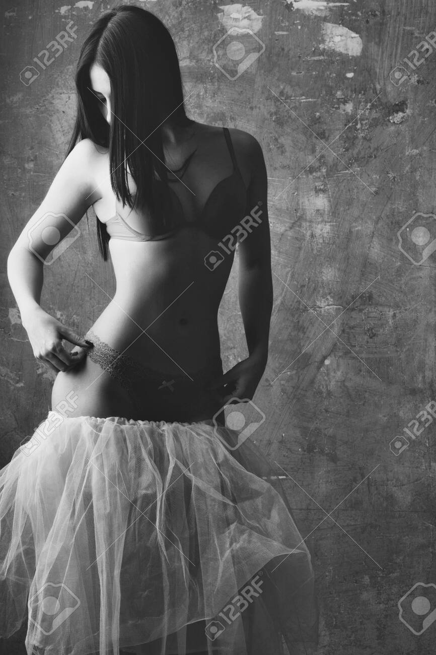 きれいな女の子やセクシーなピンクのスカート パンティーとブラジャー美しい体に織り目加工の壁背景で長いブルネットの髪でかわいいおしゃれな女性 の写真素材 画像素材 Image