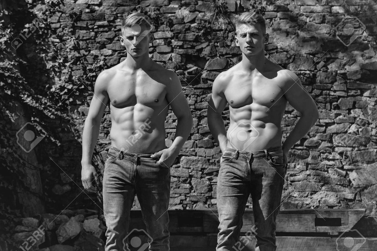 Hermanos Gemelos Dos Culturistas Musculosos Con Pecho Desnudo Hombres  Jóvenes Fuertes Modelos Sexy En Jeans Pie Manos En Los Bolsillos En El  Fondo Mural Fotos, retratos, imágenes y fotografía de archivo libres