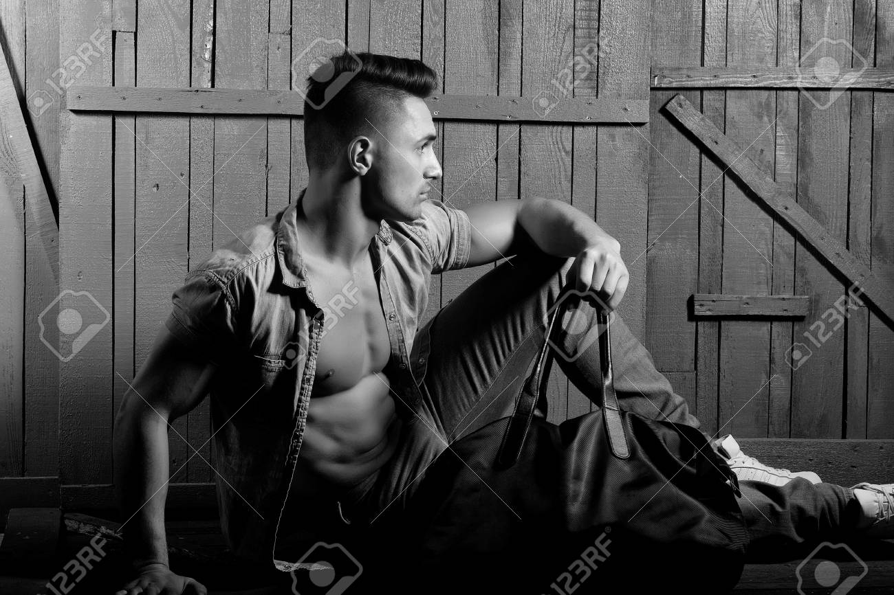 木製の背景に屋内座ってスポーツバッグを保持しているジーンズシャツで裸の胴体とスタイリッシュな髪を持つイケメンファッショナブルセクシー官能筋肉若い男らしく男 横長の画像 の写真素材 画像素材 Image 53