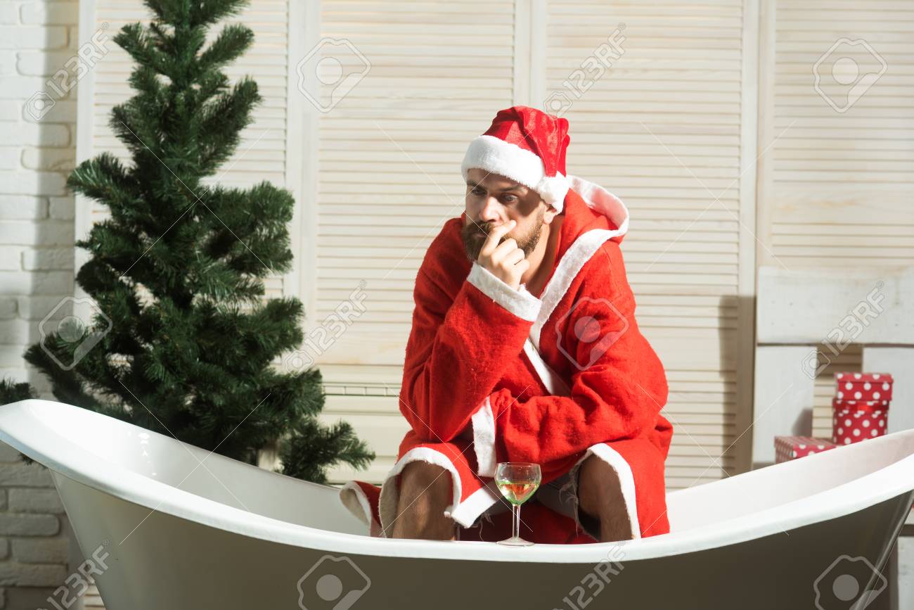 あごひげのクリスマス男 待ってるクリスマスツリーのヒップスターサンタはワイン 孤独を飲みます 期待 愛と裏切り 冬休みとマスパーティー 一人で家 風呂で悪いサンタ の写真素材 画像素材 Image