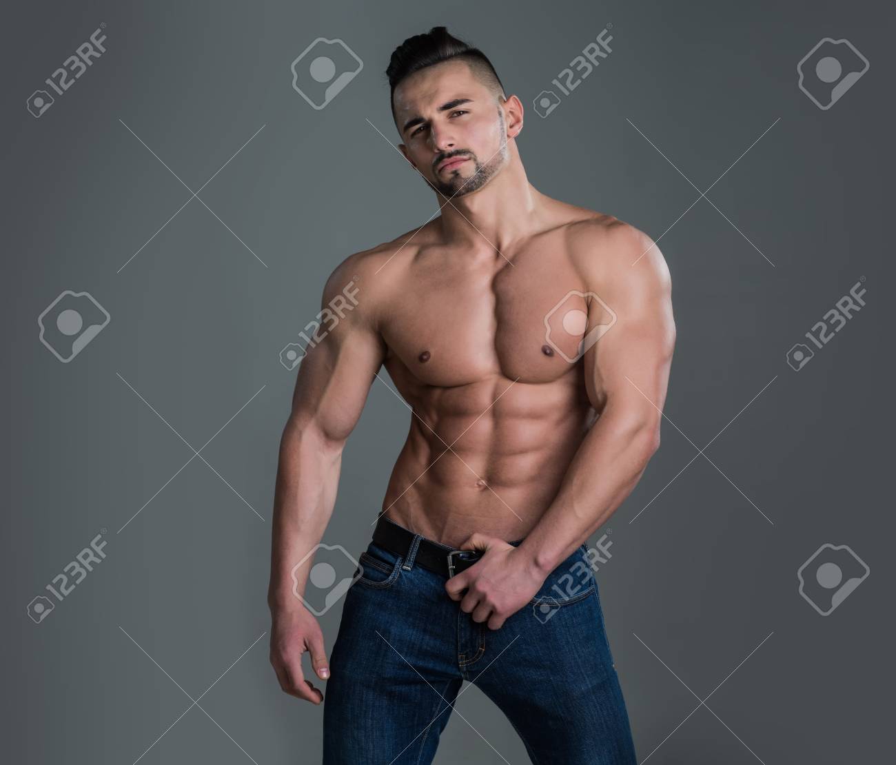 Mann Mit Muskulösem Körper Und Torso . Trainer Sportler Mit Nackten Brust  In Jeans . Sport Und Training übung Auf Grauem Hintergrund . Fitness Und  Attraktiv Lizenzfreie Fotos, Bilder Und Stock Fotografie. Image 92579714.