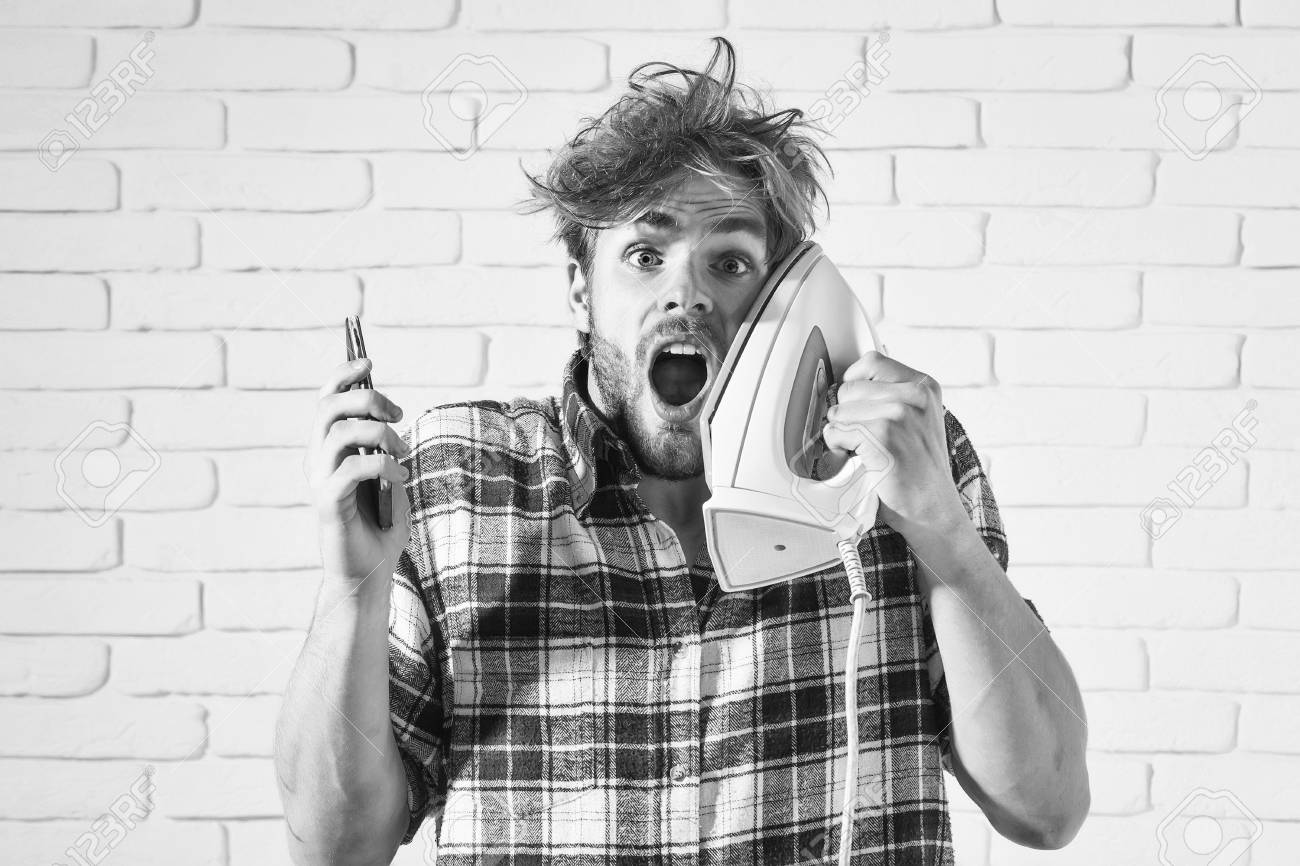 Handsome Surprised Man With Messy Hair With White Iron At His