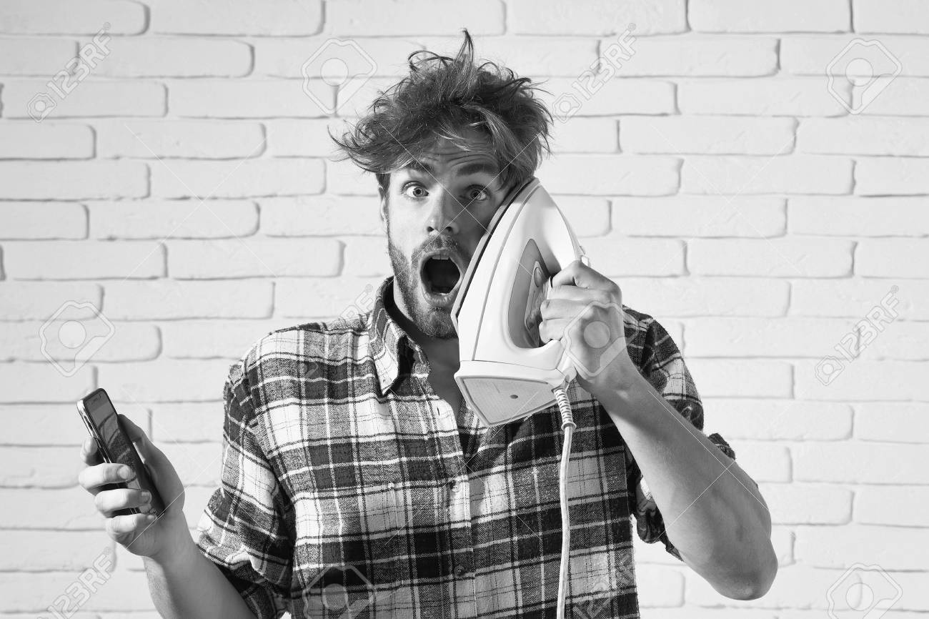 Handsome Surprised Man With Messy Hair With White Iron At His