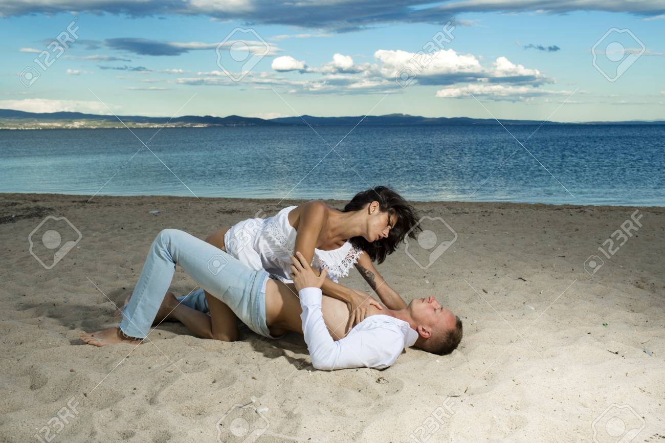 ビーチのコンセプトでセックス。欲望の完全なカップルは、海岸の砂の上にセックスを持っています。海岸、海を背景に愛を作る官能的な愛好家。愛のカップルは セックスを持って、砂浜で愛を作ります。の写真素材・画像素材 Image 99152836