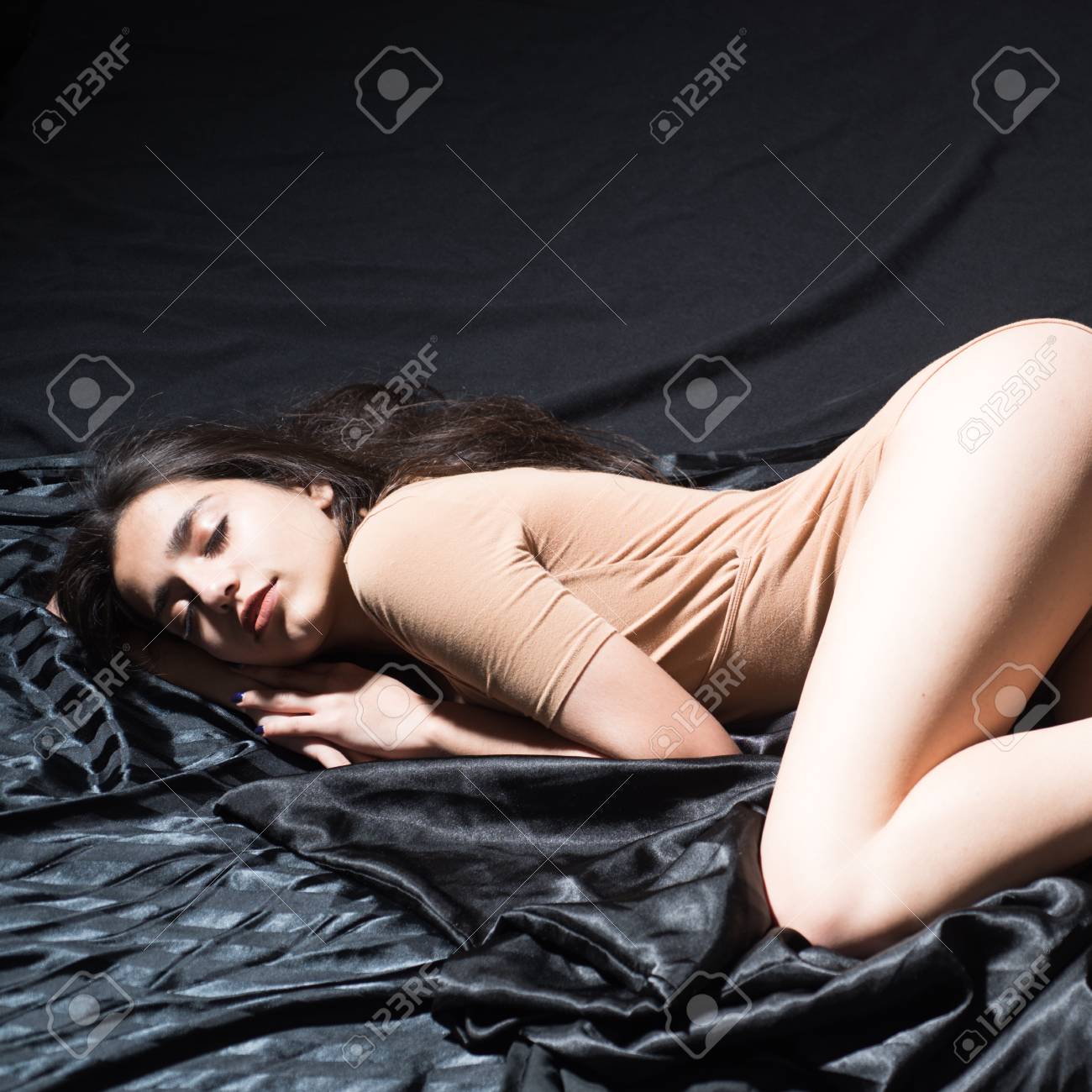 Stock Photo Young Female Lying In Cozy Bed Sexy Girl In Beige Body Suit On Black Background Sensual Girl Falling Asleep Erotic Fantasy Concept Stock Photo Young Female Lying In Cozy Bed Sexy Girl In Beige Body Suit On Black Background Sensual Girl Falling Asleep Erotic Fantasy Concept