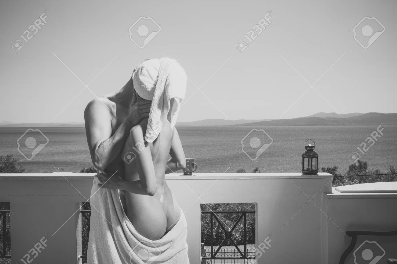 Sensual young couple making love in bedroom. Man and lady makes love. Couple in love hugs and kissing on balcony, sea on background. Couple in towels have on terrace on sunny day. Romantic and honeymoon concept - 102000925 Sensual young couple making love in bedroom. Man and lady makes love. Couple in love hugs and kissing on balcony, sea on background. Couple in towels have on terrace on sunny day. Romantic and honeymoon concept - 102000925