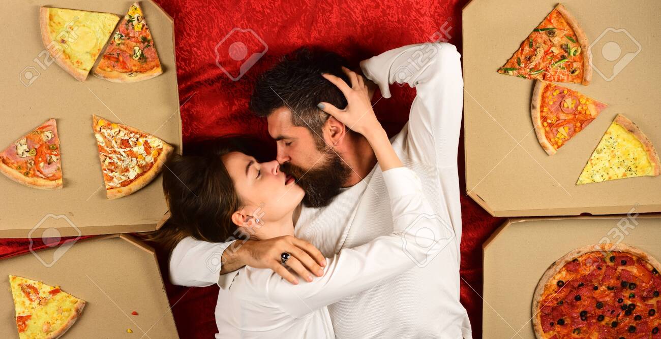 Pizza Party. Pizza Delivery. Beautiful Girl Nude Body And Bearded Macho.  Snack After Sex. Lazy Couple Spend Time In Bedroom. Sexy Couple Eat Pizza  In Bed. Couple Relaxing In Bed With Pizza