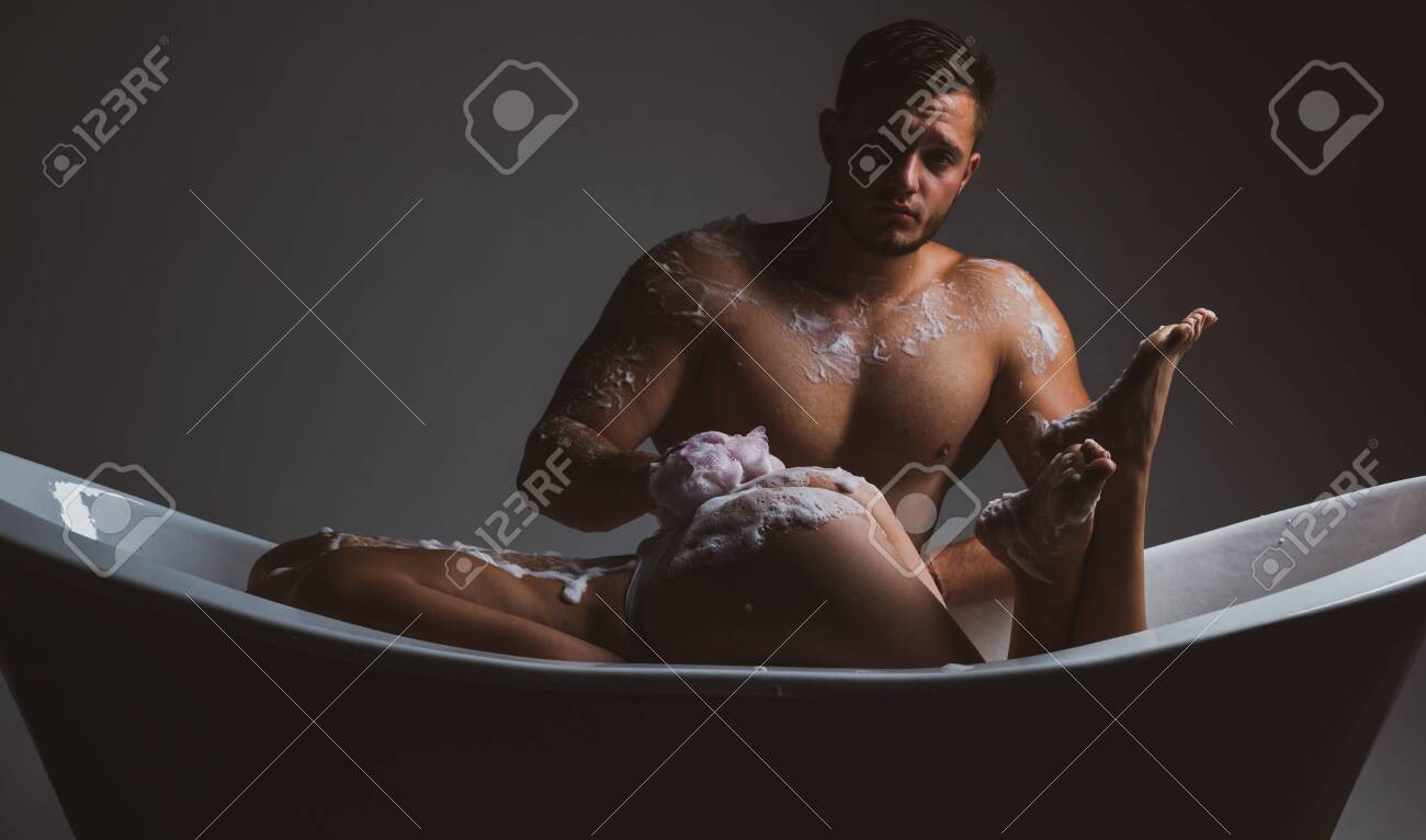 Couple In Bathroom. Prelude Couple In Love. Girl Washing In Bath With Foam. Sex Games And Orgasm. Spa And Relaxation. Isolated On Dark photo