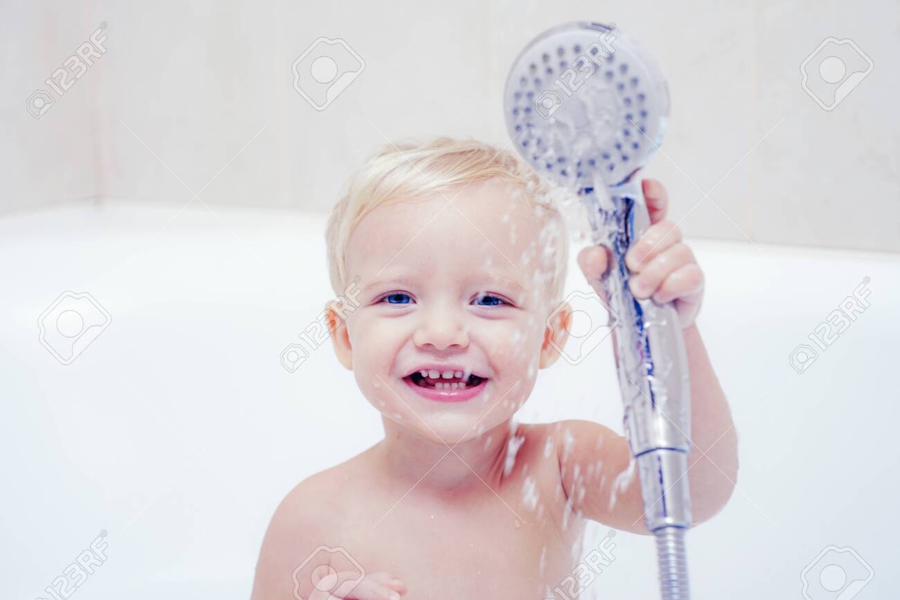 Cute baby is washing her hair in bath. Concept for healthcare and daily routine. Baby with a towel after taking a bath. Kid bath. - 140861128 Cute baby is washing her hair in bath. Concept for healthcare and daily routine. Baby with a towel after taking a bath. Kid bath. - 140861128